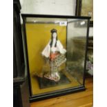 A Japanese porcelain doll in glazed display case.