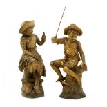 Pair of Goldscheider, Wien, terracotta figures of young fisher folk decorated with parcel gilt,