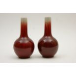 Pair of Chinese sang de boeuf miniature bottle vases, deep red glaze,