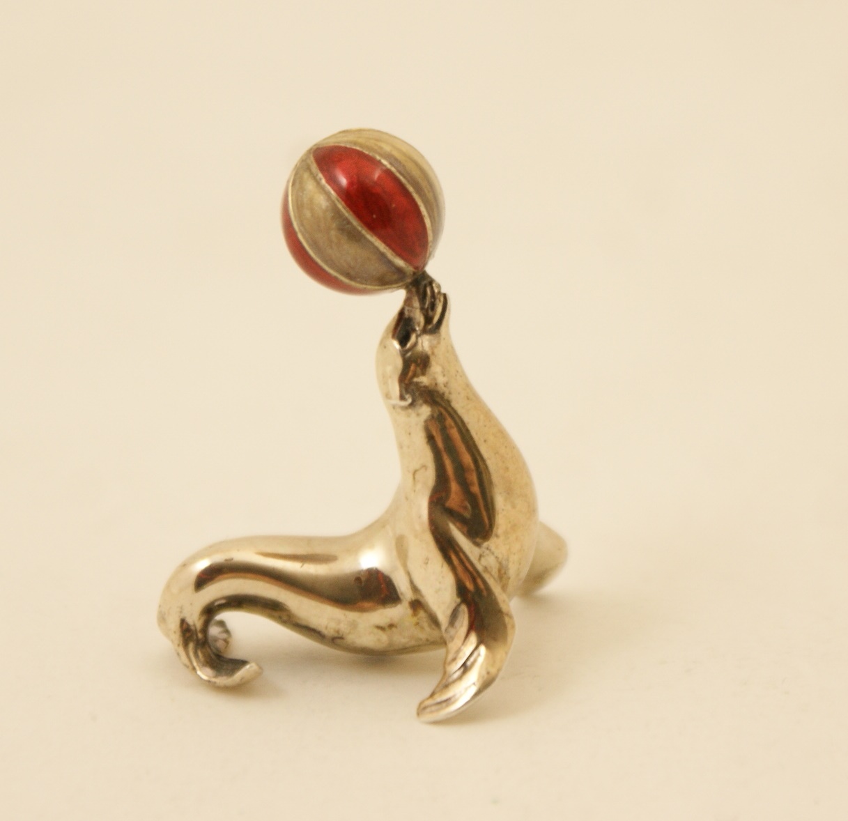 Modern silver and enamelled sea lion, worked balancing a ball on its nose,