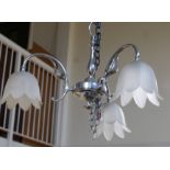 Chrome three branch chandelier supporting three frosted glass tulip shades,
