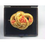 A late Victorian yellow metal brooch, elaborate scroll design with filigree, applied coral