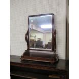 A Victorian mahogany dressing mirror, rectangular bevelled plate adjustable on rounded rectangular