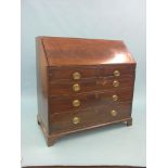 A George III mahogany bureau, feather-veneered fall-front enclosing an arrangement of drawers,