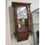 A late 19th century American wall clock, enamelled dial with bell-striking movement, stained beech