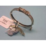 A white metal bangle, with pierced detail and yellow metal buckle, together with a 14ct. gold and