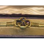 A late Victorian engraved yellow metal bracelet, flower-scroll design set four amethysts, 16.3 grams