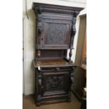 A late 19th century Flemish-style dark oak hall cupboard, upper stage with single cupboard, panelled