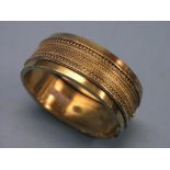 A Victorian 15ct. gold bangle, with filigree border, 33 grams