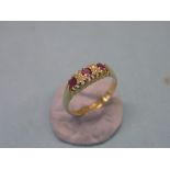 An 18ct. gold half-hoop ring, three rubies and four small diamonds, claw setting, Birmingham 1916,