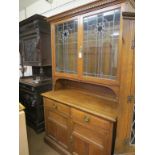 A late Victorian solid, medium oak sideboard, pair of leaded glazed doors enclosing two adjustable