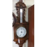 A Victorian carved oak wheel barometer, with printed thermometer and barometer dials, 38in.