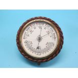 A late Victorian aneroid barometer, circular-shape in carved oak rope-twist surround, printed