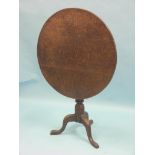 A George III oak tilt-top tripod table, circular top on turned pedestal stem, 2ft. 7in.