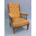 A Victorian mahogany armchair, with spindle arm-supports, upholstered in a buttoned striped