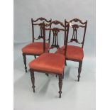 A set of three late Victorian dark mahogany drawing room single chairs, with carved rosettes and