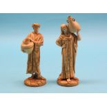 A pair of Royal Worcester water carriers, bearded male, fully-robed female, gilded against an