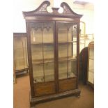 A Chippendale-style mahogany display cabinet, pierced swan-neck pediment above a pair of full-length