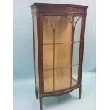 An Edwardian mahogany display cabinet, single, bow-fronted door with astragal mouldings, two