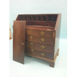 A George III mahogany bureau, fall-front enclosing an arrangement of pigeonholes and drawers, four