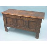 An early 18th century oak coffer, panelled construction with boarded top, frontage with incised