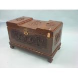 An Oriental camphorwood blanket chest, carved throughout with figures and foliage, engraved brass