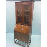 An early 20th century solid, dark oak bureau bookcase, pair of leaded glazed doors enclosing two