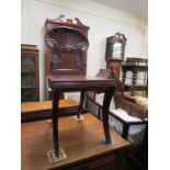 A George IV mahogany hall seat, boldly-carved oyster shell back, front moulded sabre legs, back