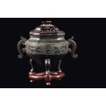 A bronze tripod censer and wooden cover with a geometric archaic style motif, China, Ming Dynasty,
