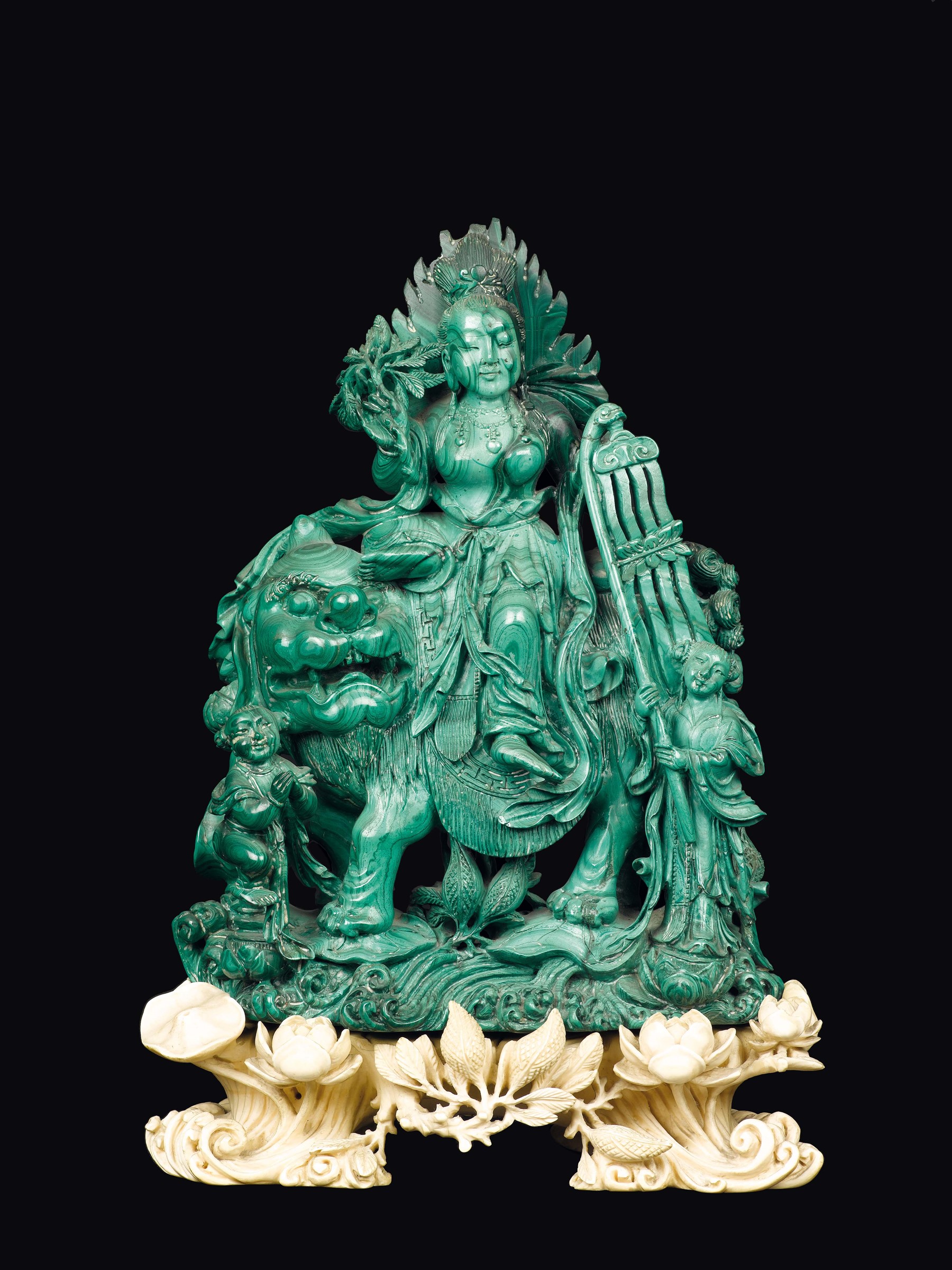 A finely carved malachite group with Guanyin on a Pho dog and children with carved ivory stand,