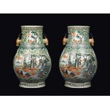 A pair of polychrome enamelled porcelain vases with deer-handles depicting court life scenes