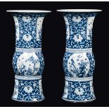 A pair of blue and white trumpet vases with flowers and birds within reserves, China, Qing