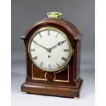 An early 20th Century mahogany cased mantel timepiece of Georgian design, the 7.75ins diameter domed