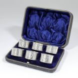 A set of six George V silver circular napkin rings, the rims with zigzag ornament and each No. 1-6