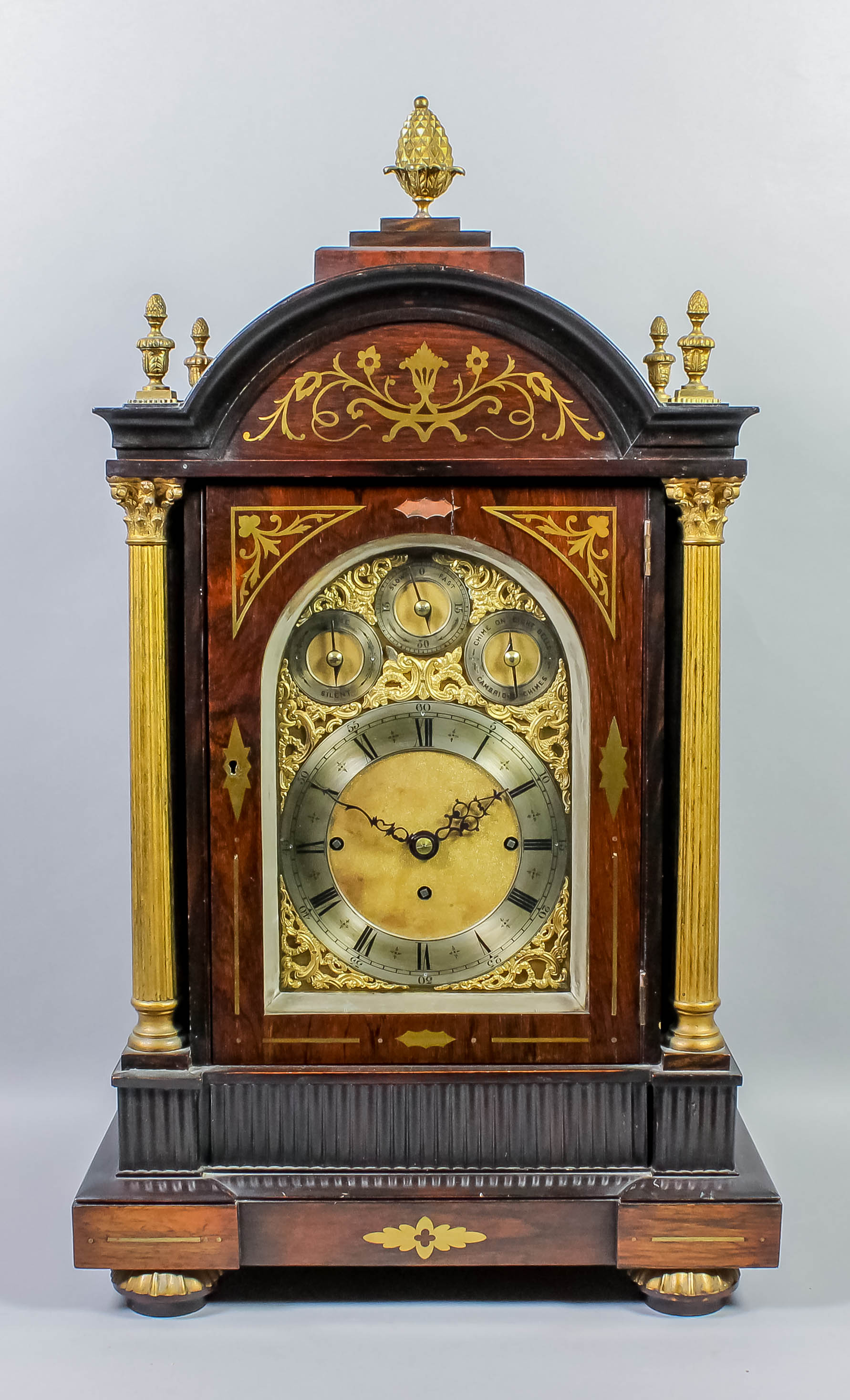 A late 19th Century rosewood and brass inlaid cased mantel clock, the arched brass dial with 6.75ins