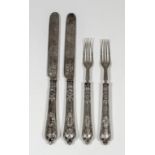 A set of six Victorian silver fruit knives and forks, the handles embossed with strapwork