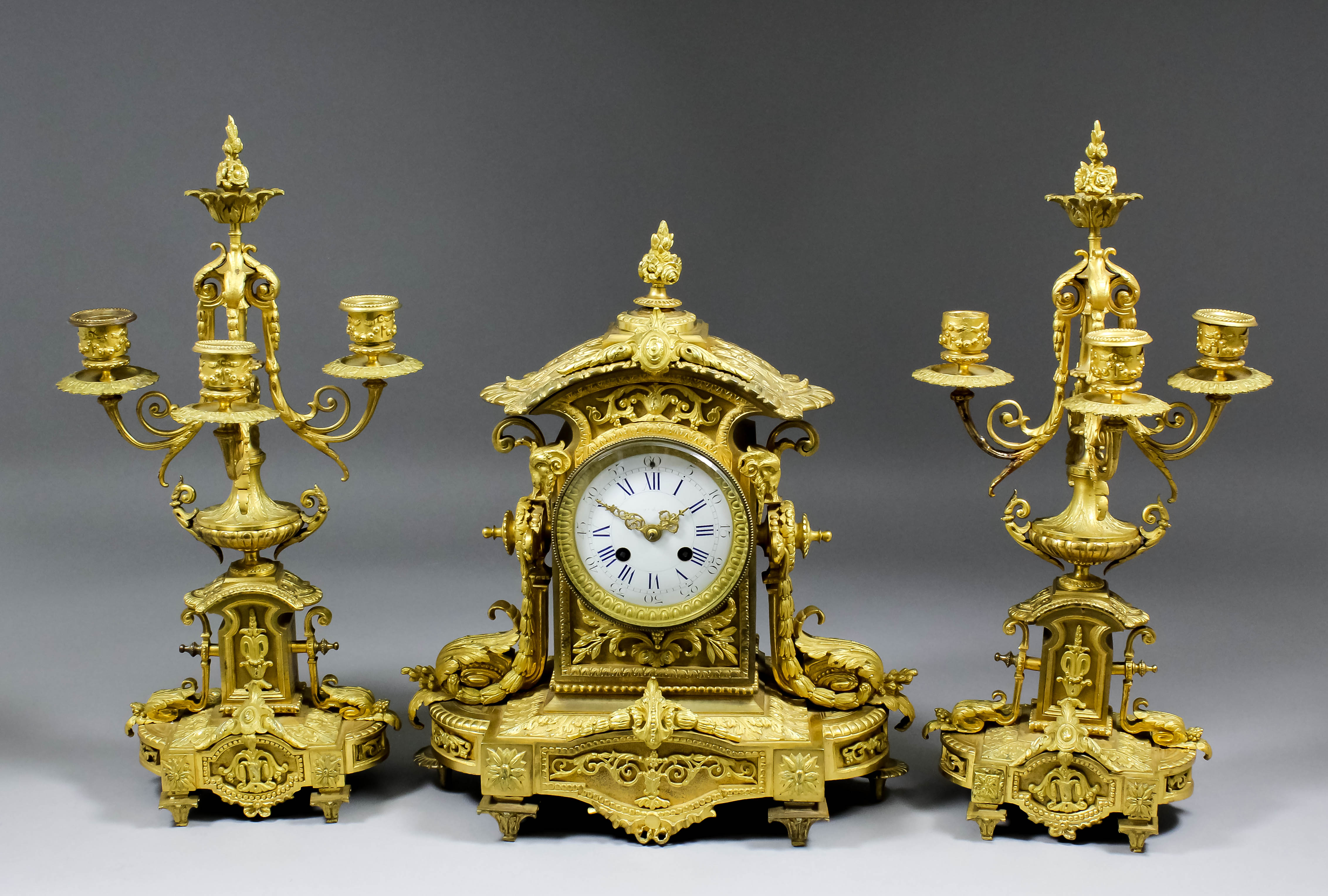 A late 19th Century French gilt brass cased three piece clock garniture, the clock by Japy Freres,