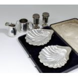 A pair of late Victorian silver shell pattern butter dishes, each on three shell pattern supports,
