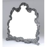 A late Victorian silver framed dressing table mirror of shaped outline, the silver pierced and