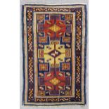 A Daghestan rug woven in colours with three bold stepped medallions filled with cross motifs on a