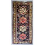A Shiraz long rug woven in colours with four bold eight pointed star motifs filled with hooked