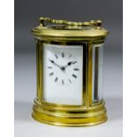 A late 19th/early 20th Century French oval carriage clock, the white enamelled dial with Roman