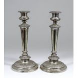 A pair of George IV silver pillar candlesticks with leaf cast mounts, urn pattern sconces, tapered