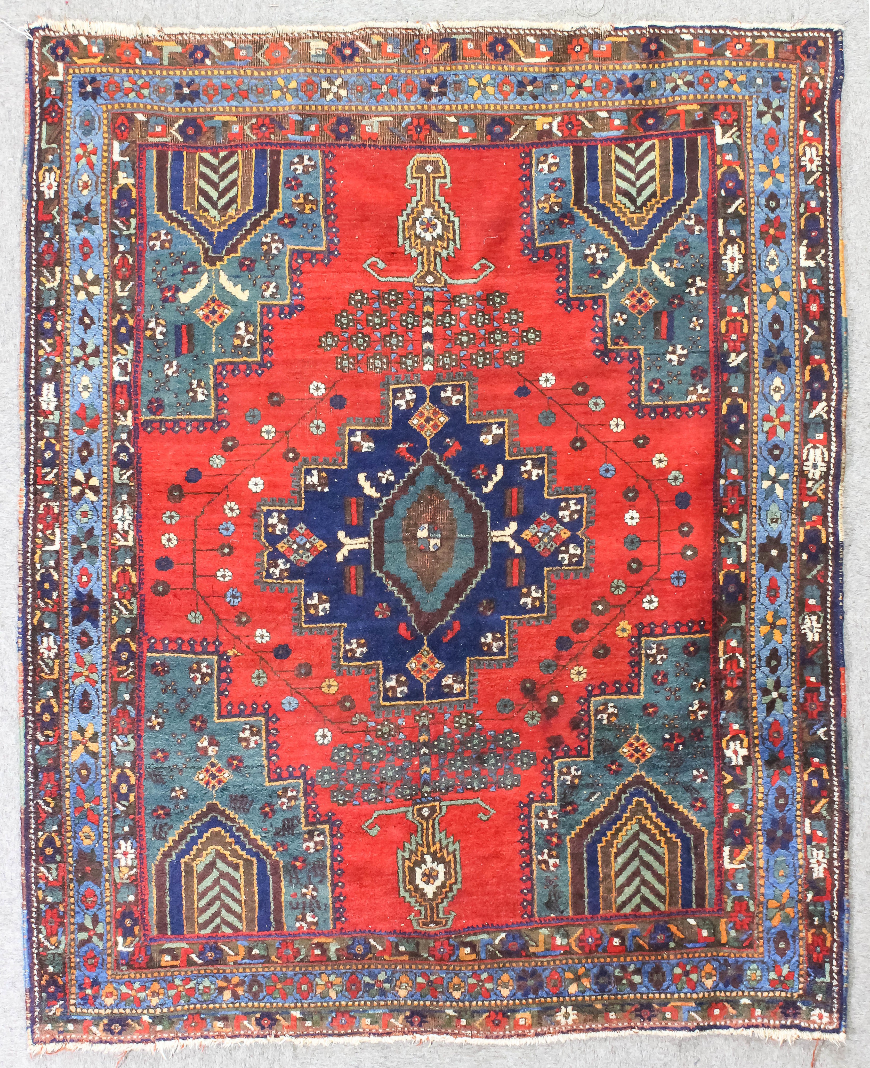 An antique Afshar rug, woven in muted colours and ivory with central stepped medallion, spandrals