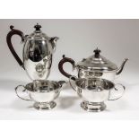 A George V silver circular four piece tea service with moulded rims and girdles, C-scroll handles