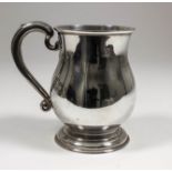 An Elizabeth II silver baluster shaped tankard with moulded rim and footrim and scroll handle,