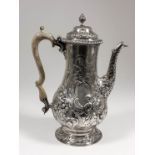 A George III silver baluster shaped coffee pot of large proportions, the domed cover with leaf