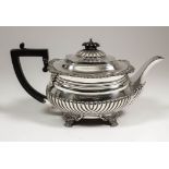 A George V silver rectangular teapot with gadroon, shell and leaf cast mounts, part reeded body,