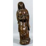 A 16th Century French carved oak figure of St. Anne, her hands together in an attitude of prayer,