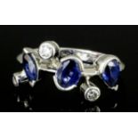 A modern Cartier melimelo platinum mounted sapphire and diamond ring, the face set with a marquise